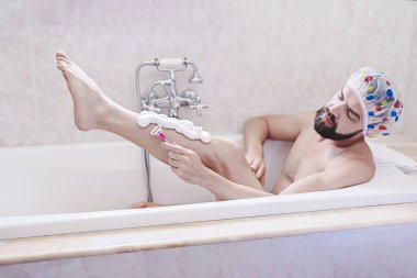 Duş boneli sakallı adam banyoda tıraş olurken rahatlıyor. Deri ve öz bakım kavramı, erkek sağlığı konudur.