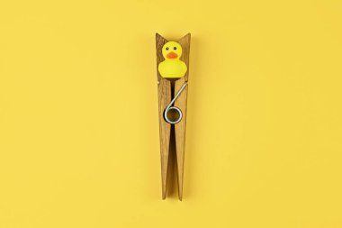 Large clothespin with yellow duck triggers playful prank on April Fool day, prank offering sudden confusion. Prank boosting comedic tension in daily routine for unexpected fun clipart