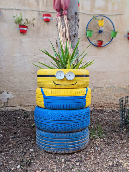 Upcycled tires become artistic garden planters, showcasing handmade creativity. Playful faces and bold colors enhance outdoor aesthetics, proving sustainability can be stylish