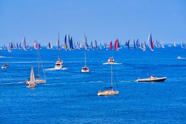 Malta yakınlarındaki mavi Akdeniz 'de yarış teknelerinin manzarası, renkli yelkenler, berrak gökyüzü altında sakin deniz: Valletta, Malta - 19 Ekim 2019