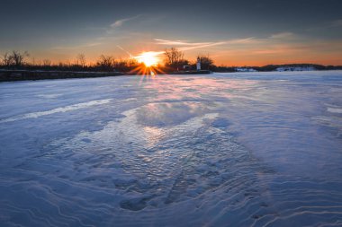 Quebec 'in kış manzarası ve donmuş St. Lawrence nehri üzerinde gün batımı. 2024
