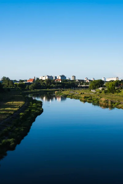 Arka planda mavi gökyüzü ve nehri olan küçük bir şehir. 