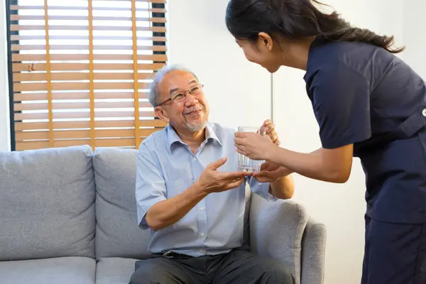 Smiling Nurse Giving Glass Water Senior Asian Man Nursing Home Royalty Free Stock Images