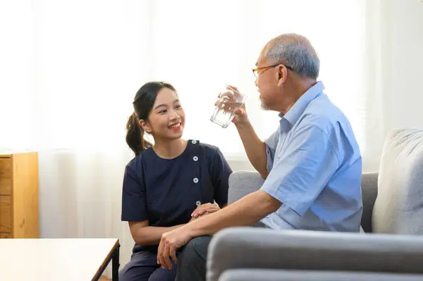 Smiling Nurse Giving Glass Water Senior Asian Man Nursing Home Stock Photo