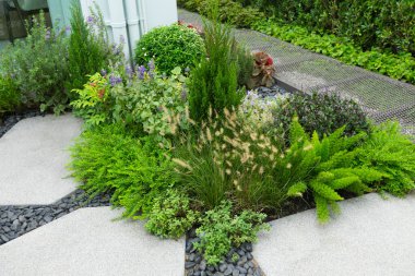 Güzel yeşil izin ve çiçeklerle dekore edilmiş bir evin bahçesinde..