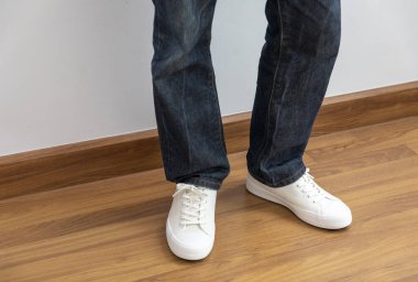 Odanın ahşap zemininde erkek moda ayakkabıları.