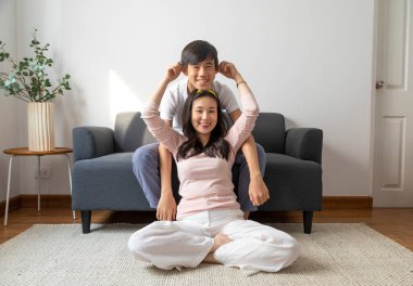 Genç Asyalı bir aile evde oyun oynuyor ve eğleniyor..