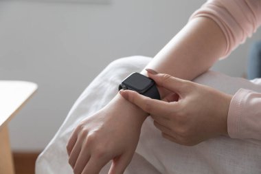 Evde kol saati olan bir kadın var. Yakın plan.