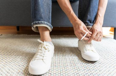 Ayakkabı bağcıklarını bağlayan adamın kırpılmış görüntüsü