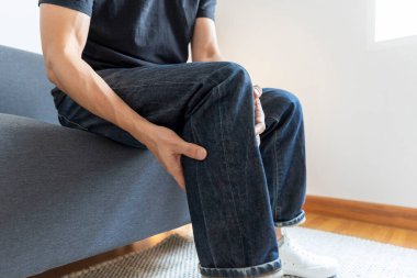 Evdeki koltukta acı çeken bir adam.