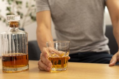 Alkol alan ve alkolik olan genç bir adam.