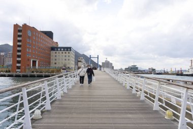 İnsanlar iskelede yürüyor.