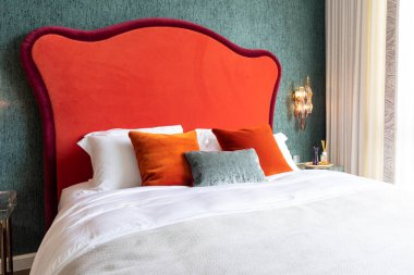 Lüks yatak odası içinde yatak, lamba ve yastıklar var.