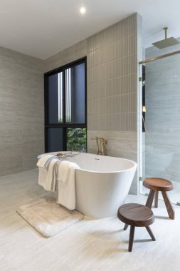 Beyaz küveti ve ahşap zemini olan modern banyonun iç tasarımı.