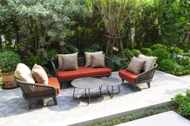 Kanepesi ve masası olan bir bahçe.