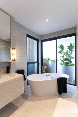 Büyük beyaz küveti olan güzel bir banyo.