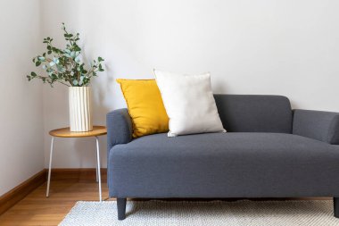 Gri masalı yastıklı ve yastıklı modern kanepe