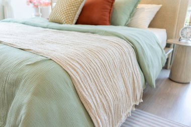 Açık mavi battaniyeli yatakta rahat bir yastık.