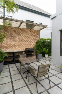 Teras masası ve sandalyesi olan modern bir bahçe.