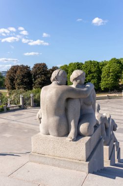 Parkın arka planındaki kadın ve erkeğin heykeli..