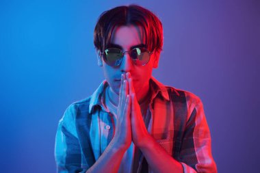 Stylish look. Man standing in the studio with neon light.