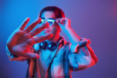 Stylish look. Man standing in the studio with neon light.