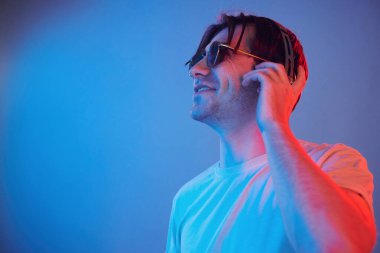 Side view. Man standing in the studio with neon light.