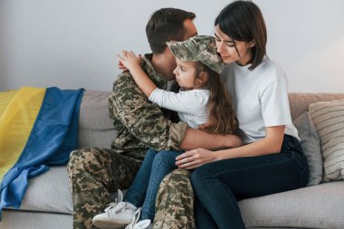 Ukrayna gebeliği. Üniformalı asker karısı ve kızıyla birlikte evde..