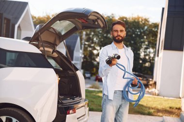 Sarı kabloyu tutuyorum. Genç şık adam, gündüz vakti elektrikli arabayla geziyor..