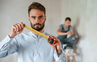 İki adam dairede birlikte tamirat yapıyor..