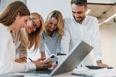 Birlikte dizüstü bilgisayarla çalışıyoruz. Profesyonel iş adamlarından oluşan bir grup ofiste..