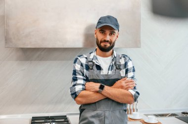 Kollarını kavuşturmuş duruyorsun. Üniformalı tesisatçı evde..