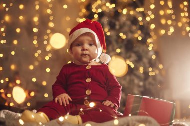 Noel Baba şapkalı. Sevimli küçük bebek evde. Yeni yıl süslemeleri. Tatil kavramı.