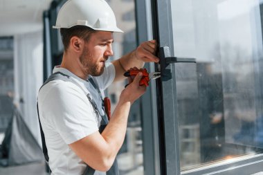 Pencerelerdeki aletleri kullanarak. Tamirci modern odada kapalı alanda çalışıyor..