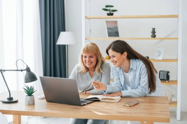 Modern teknolojilerin nasıl kullanılacağını öğreniyorum. Akıllı telefon ve dizüstü bilgisayar. Anne ve kızı evde birlikteler..