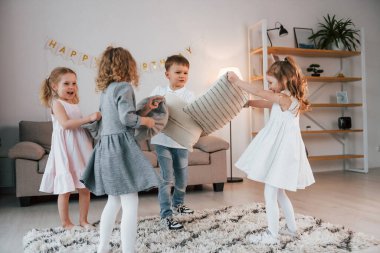 Doğum günü partisinde yastık savaşı. Bir grup çocuk gündüzleri evde birlikteler..