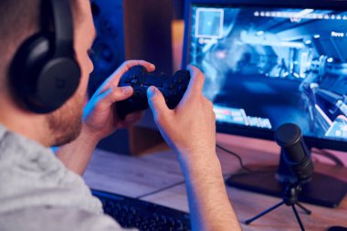 Oyun kumandasını kullanarak. Evde FPS nişancı oyunu oynayan çevrimiçi flamalar.