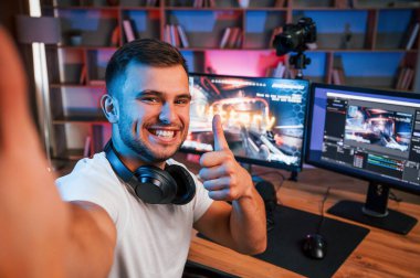 Selfie çekmek, zaferi kutlamak. Günlük giysiler içindeki erkek oyun flaması içeride bilgisayar ile birlikte..