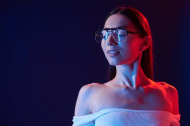 Güzel görünüş. İçerideki neon ışıkta duran genç bir kadının portresi..