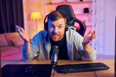 Mikrofona çevrimiçi izleyicilere konuşuyorum. Kulaklıklı ve mikrofonlu adam canlı yayında..