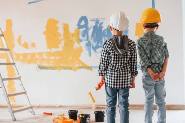 Hayal gücü kavramı, sanat. İki çocuk ev odasında duvar boyuyor..