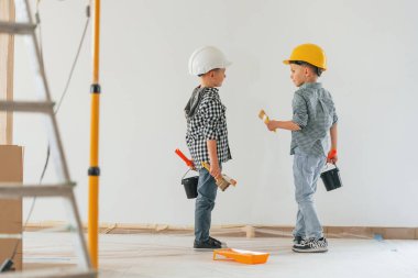 Neşeli çocuklar. İki çocuk ev odasında duvar boyuyor..