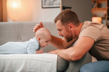 Kafasını okşuyor. Yeni doğmuş bebeğiyle baba içeride. Bekar baba kavramı.