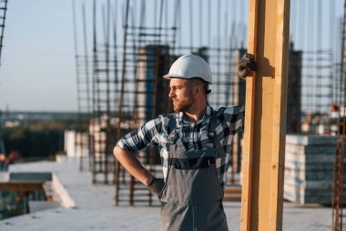 Adam gündüz vakti şantiyede çalışıyor. Büyük ahşap tahtayı hareket ettiriyorum..