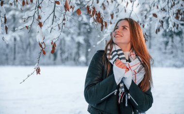 Karla kaplı ağacın dallarının altında duruyorlardı. Güzel genç bir kadın kış ormanında dışarıda..