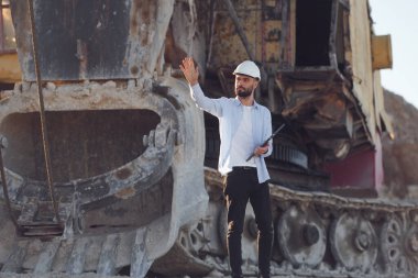 Dizüstü bilgisayarla. Üniformalı adam gündüz taş ocağında çalışıyor..