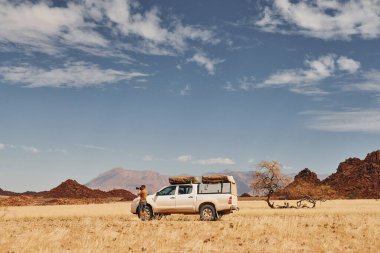 Afrika, Namibya çöllerindeki arabanın yanında fotoğrafçı..