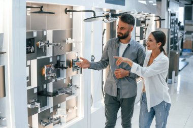 Ayakta duruyorum ve ev için yeni malzemeler arıyorum. Kadın ve erkek mal deposunda..