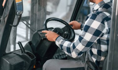 Forklift 'te. Üniformalı fabrika çalışanı içeride..