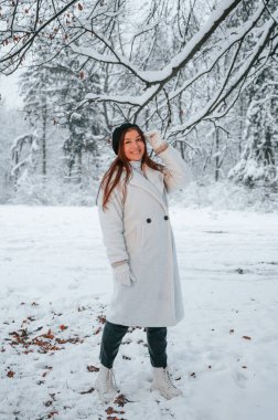 Doğanın tadını çıkarıyorum. Güzel genç bir kadın kış ormanında dışarıda..